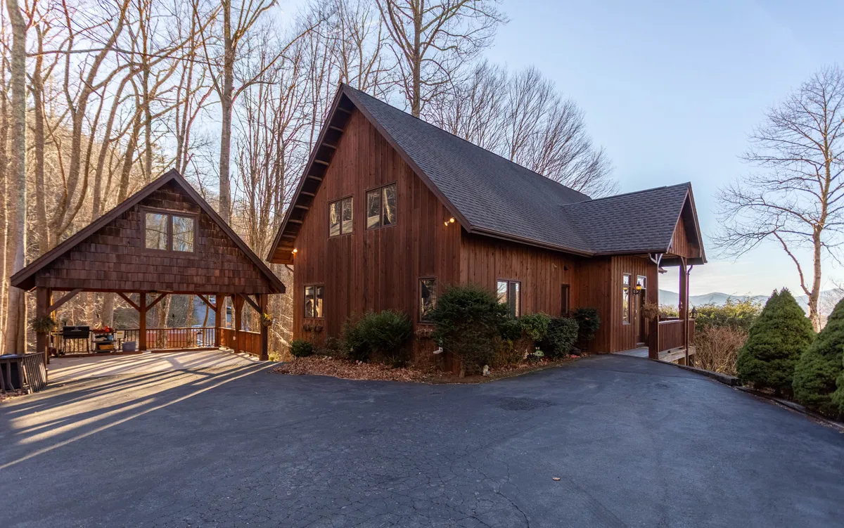 A tranquil exterior view of a wooden house with an attached gazebo, surrounded by lush trees. The space radiates relaxation and connection to nature, with areas perfect for gathering, stargazing, or sipping coffee outdoors.